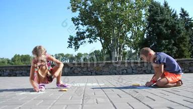 孩子们，一个男孩和一个女孩戴着太阳镜，用彩色蜡笔在沥青上画画，街道瓷砖。 <strong>炎炎夏日</strong>..